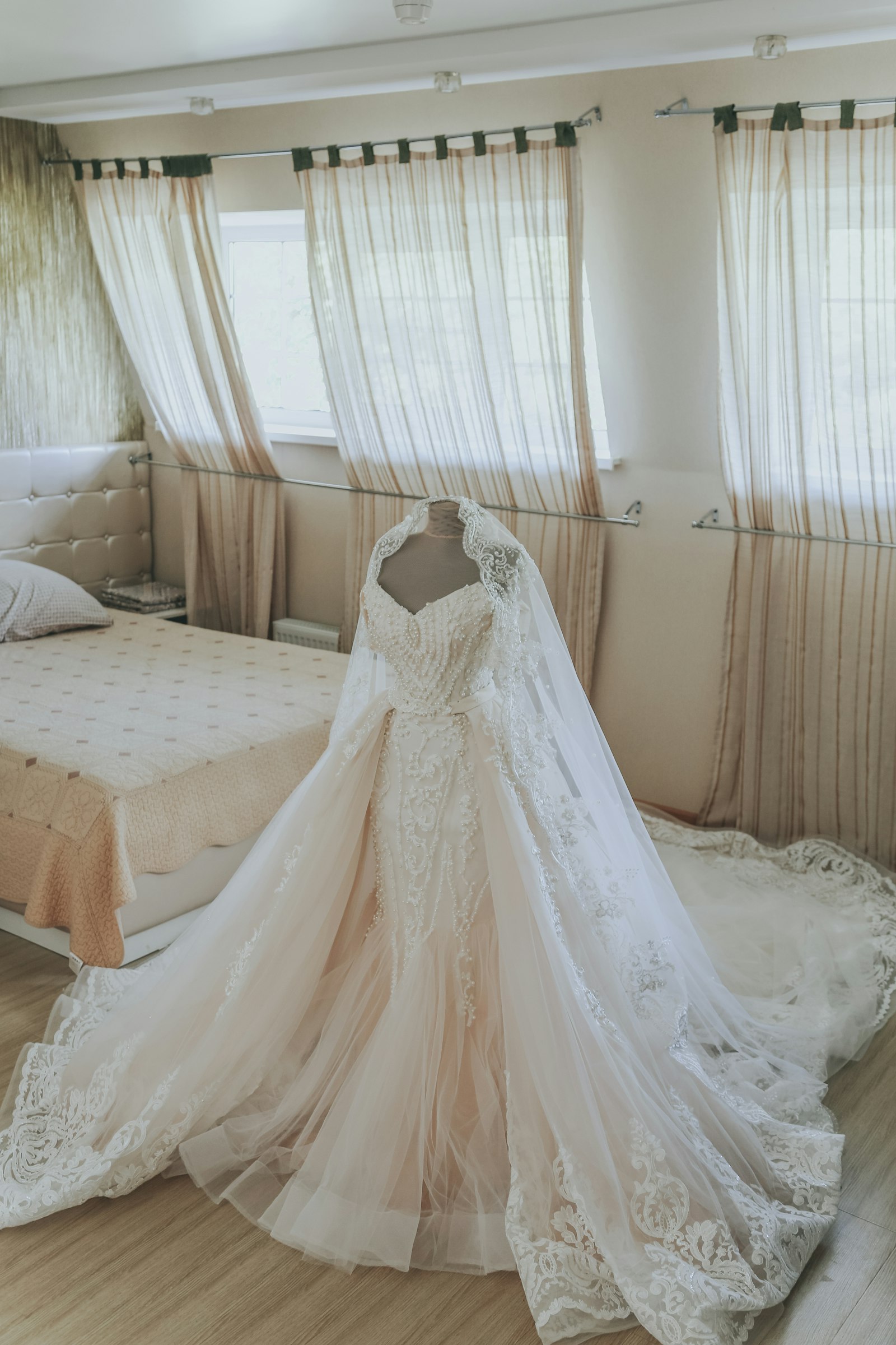 Weißes Brautkleid liegt ausgebreitet auf einem Bett